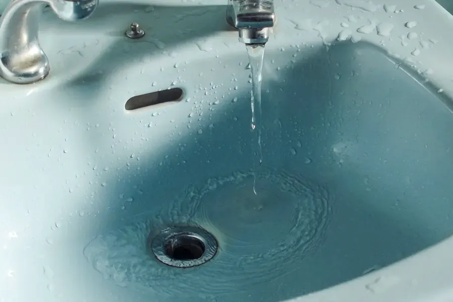 Water flowing from a faucet into a sink