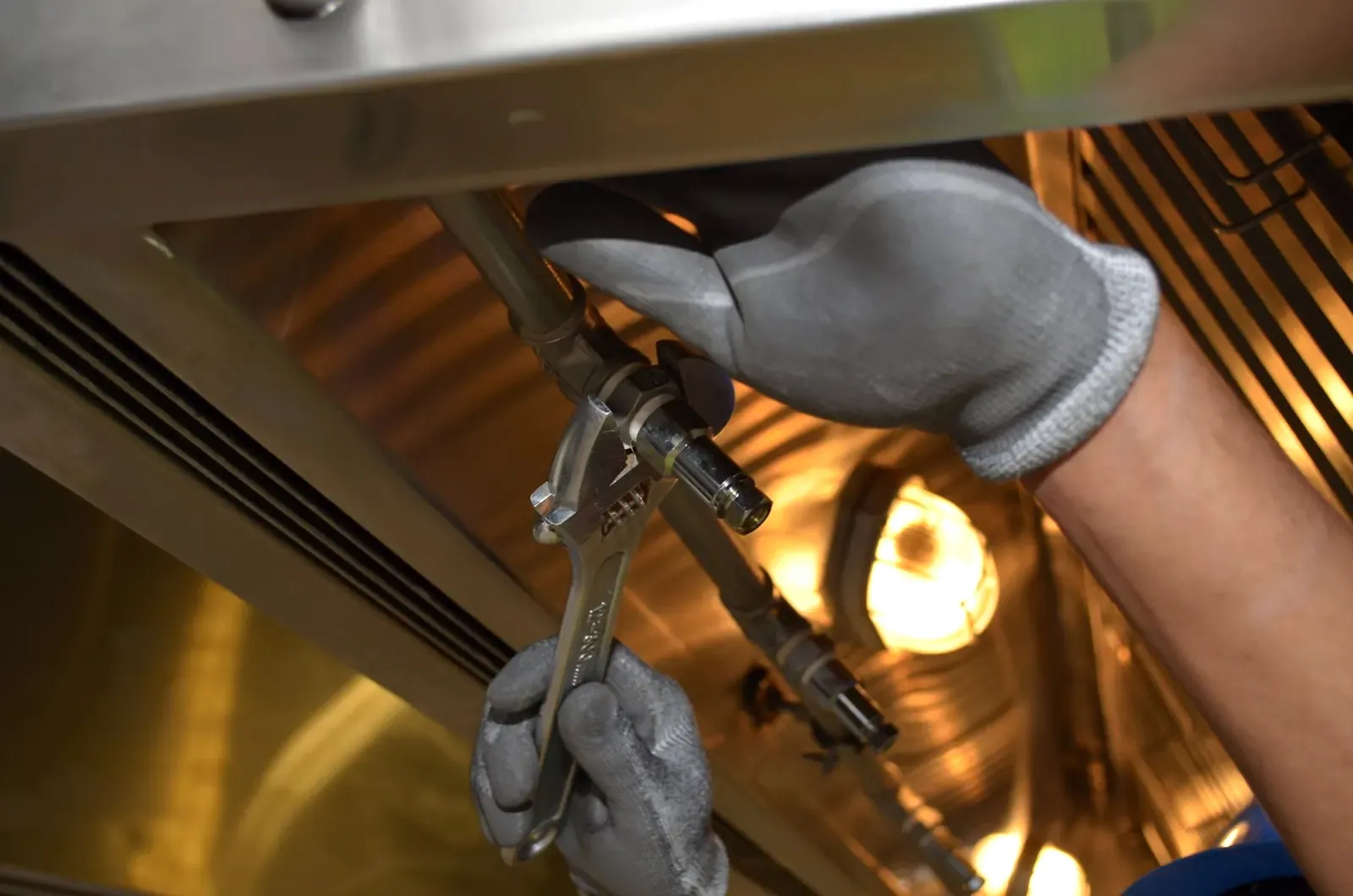 Worker repairing pipework with a spanner